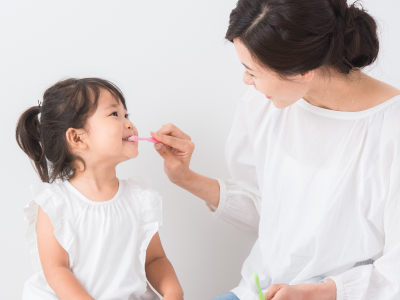 歯磨きで歯のメンテナンスをする親子